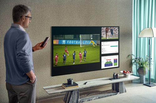 Mężczyzna stojący w salonie przy telewizorze Samsung Neo QLED QN91A MiniLED